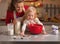 Baby helping mother make christmas cookies in kitchen