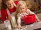 Baby helping mother make christmas cookies in kitchen