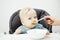 Baby in highchair eats cream soup with mothers help