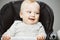 Baby in highchair with interested look and broad smile