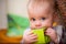 Baby holding a green block facing