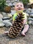 Baby holding Sugar Pine pinecone