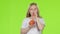 Baby holds an apple in her hands and drinks juice from it. Green screen