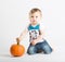 Baby Holds Pumpkin Stem Kneeling