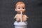 Baby human doll drinking with a paper straw