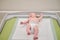 The baby infant boy lies in a diaper on the changing table in the clinic. Happy child changing clothes on nappy before appointment