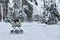 Baby infant stroller in snow in winter forest. It`s cold. Infant baby sleep inside the pram on fresh air