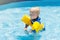 Baby with inflatable armbands in swimming pool.