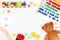 Baby kids toys background with teddy bear, toy tools, wooden train, cars and colorful blocks. Top view, flat lay