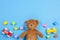 Baby kids toys background. Teddy bear, wooden car, colorful bricks on blue background