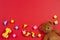 Baby kids toys background. Teddy bear, wooden car, colorful bricks on red background