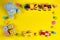 Baby kids toys background. Teddy bear, wooden train, car, colorful wood toys and bricks on yellow background. Top view