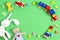 Baby kids toys background. Wooden educational toys and soft plush stuffed toys on light green background. Top view