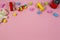 Baby kids toys frame with teddy bear, toy car, wooden train, colorful bricks on pink background. Top view