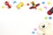 Baby kids toys frame with toy cars, teddy bear, colorful plane, wooden bricks on white background. Top view, flat lay