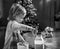 Baby kneading dough in christmas decorated kitchen