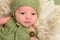 Baby in a knitted green outfit, closeup