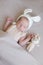 Baby in a knitted rabbit hat with ears and a bunny toy in a beige light blanket. Spring photo. Easter and children.