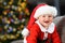 Baby laughing wearing santa disguise in christmas