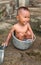 The baby laughs while shoaking in the pot