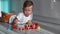 Baby lays down a train from geometric blocks. The boy 2 years lies on the floor and plays with a colorful wooden stacking train fo