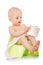 Baby learning how to use chamber pot. sitting on the potty with toilet paper rolls  on white background