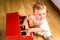 Baby learning to play the piano with a wooden toy instrument, a tender and funny childhood scene