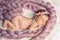 Baby little girl sweetly sleeps covered with fluffy yarn.
