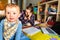 Baby looking at camera while his mother works on the computer, concept of woman`s work-life balance