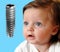 Baby looking on new dental implant isolated