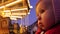 Baby looks at beautiful illuminated carousel in the evening