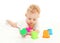 Baby lying playing with colorful toys on white