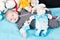 Baby lying on soft blue duvet Childhood and innocence concept Infant with blue eyes and peaceful smile among plush teddy bears