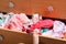 Baby makes a mess in wardrobe in open drawer with many children clothes