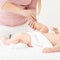 Baby massage. Female therapist gently massaging babys foot. Doctor examining infant baby boy.