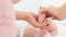 Baby massage. Female therapist gently massaging babys foot. Mother touching her newborns bare feet, bonding time.