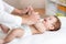 Baby massage. Massagist massaging and doing gymnastic to little kid