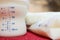 Baby milk in bottle and breastmilk in storage bags on red towel