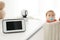 Baby monitor and camera on chest of  near crib with child in room. Video nanny