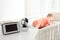 Baby monitor and camera on table near crib with child in room