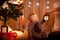 Baby near Christmas tree holding alarm clock