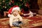 Baby near the Christmas tree. Little boy celebrati