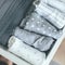 Baby or newborn things of white, blue, grey colors in drawer. Lady fly system, kondo konmary concept