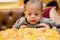 Baby next to big pizza on the table, very surprised by the size. surprised kid sitting at table.