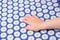 Baby palm on a blue massage acupuncture mat with white massage tips