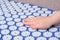 Baby palm on a blue massage acupuncture mat with white massage tips