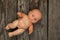 Baby plastic doll lies on a wooden table close-up
