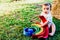 Baby playing with a colorful wooden rainbow on the grass, children`s intellectual and mental development