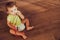 Baby playing with a medical stethoscope on the floor of his house, pediatrics concept