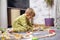 Baby playing with toy railroad, trains and cars on the floor